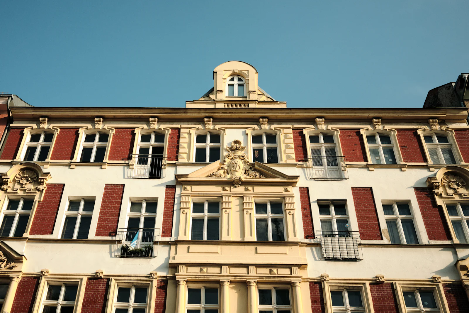 Stuckfassade eines Gründerzeit-Altbaus mit roten Fensterfaschen