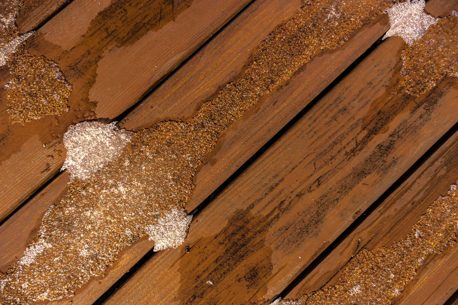 Nahaufnahme einer durchnässten Holzdiele mit dunklen Feuchtigkeitsrändern